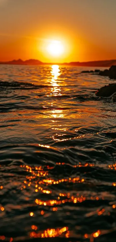 Beautiful sunset over gentle ocean waves with an orange sky.