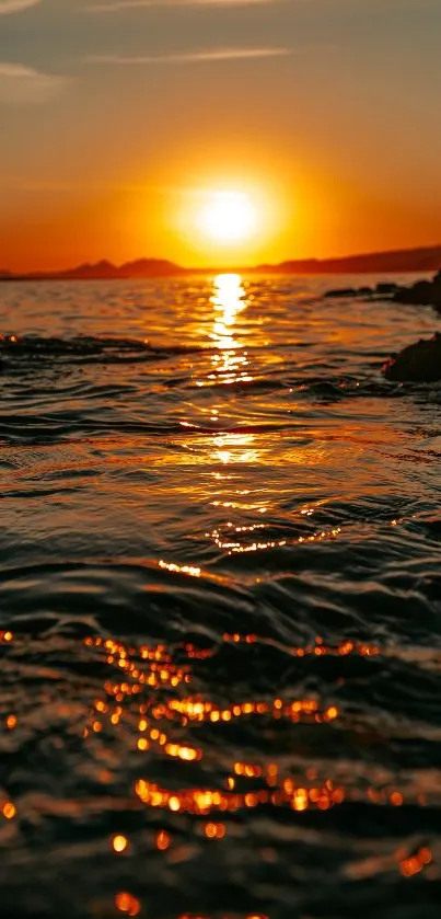 Majestic sunset over calm ocean waters with a warm orange glow.