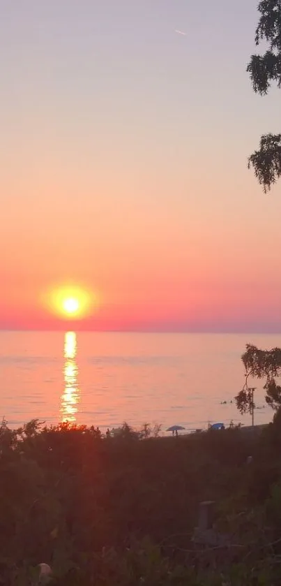 A beautiful sunset over a calm sea with pink and orange hues in the sky.