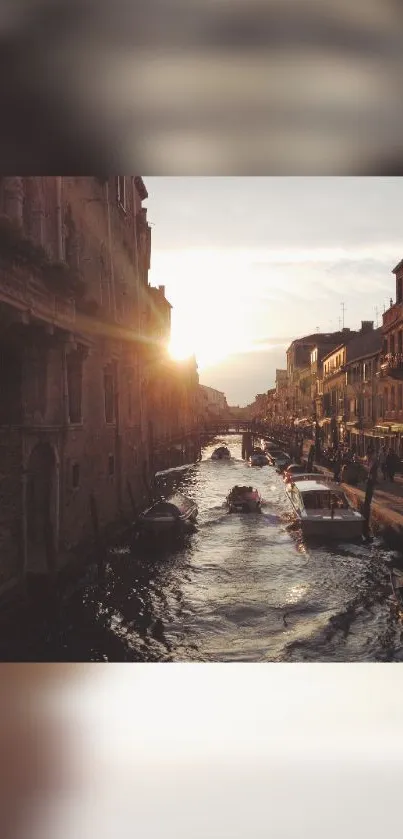 Venetian canal at sunset with boats and glowing warm hues.