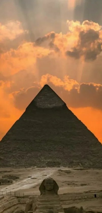 Giza Pyramid and Sphinx at sunset with orange sky backdrop.