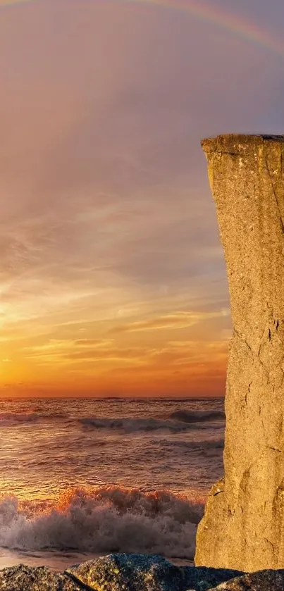 Sunset view with rainbow over ocean and cliff