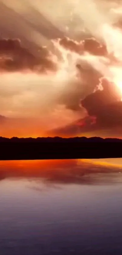 Sunset reflecting on calm water with vibrant orange and cloudy sky.