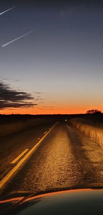 A serene road at sunset with warm colors and a glowing horizon.