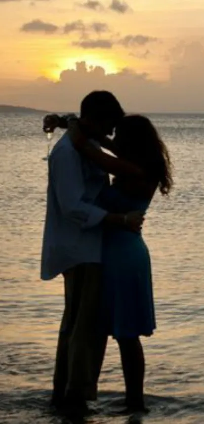 Silhouette of a couple embracing at sunset by the ocean.