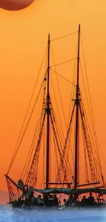 Sailboat silhouetted against an orange sunset on the ocean water scene.