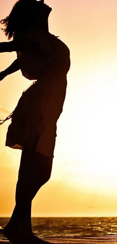 Silhouette of a woman at sunset on the beach, embracing the serene ocean view.