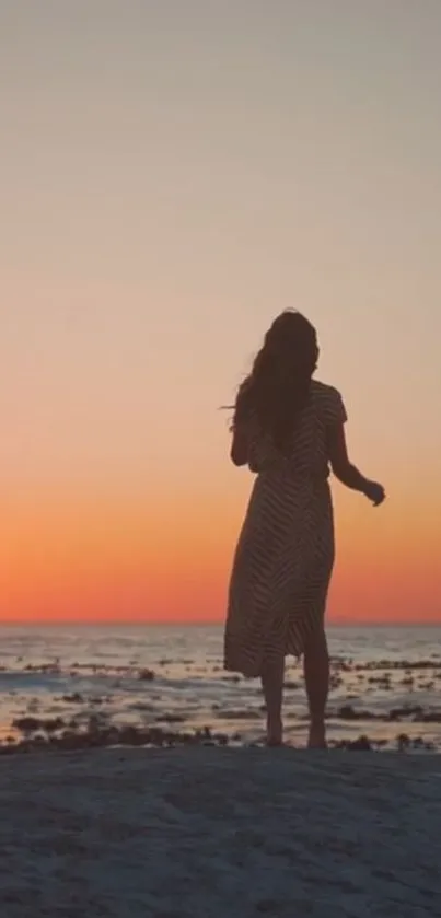 Silhouette on beach during a stunning orange sunset.