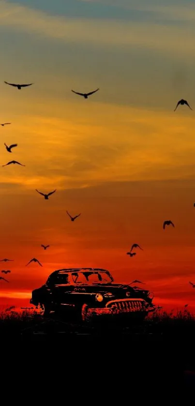 Silhouette of vintage car at sunset with birds flying.