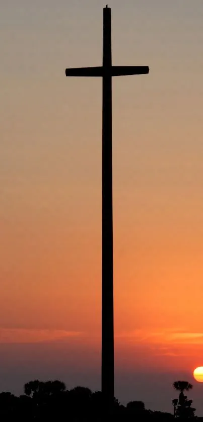 Silhouette of a cross against a vibrant sunset sky.