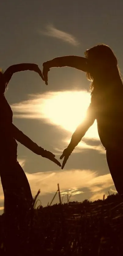 Silhouette of figures forming a heart at sunset.