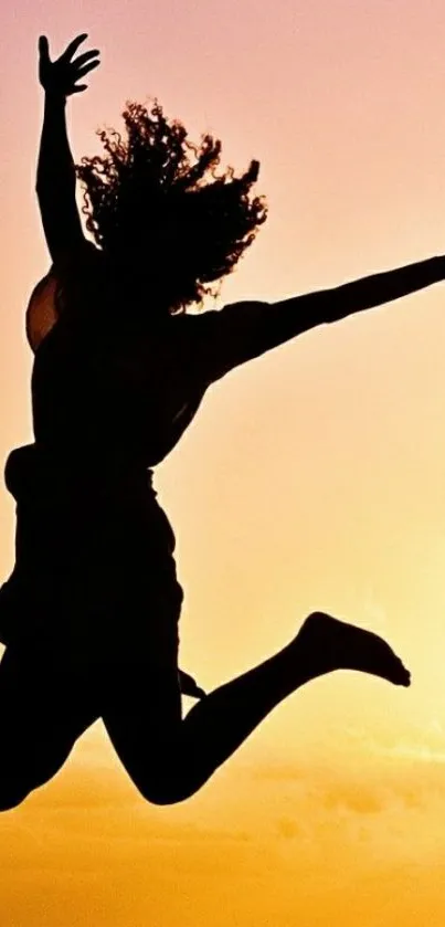 Silhouette jumping against a vibrant sunset background.