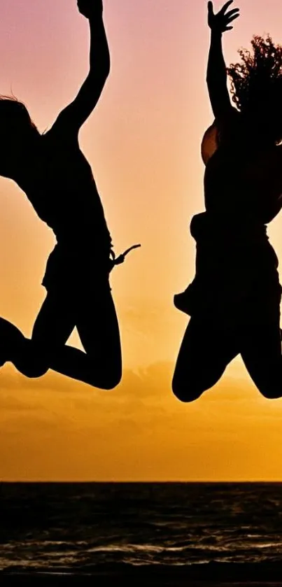 Silhouettes jumping at sunset on a beach.