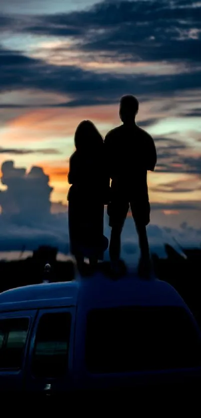 Silhouette couple at sunset on vehicle roof.