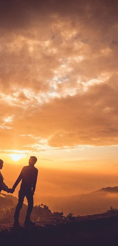 Silhouette of a couple against a vibrant sunset backdrop on a hill.