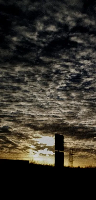 Silhouette against a dramatic sunset sky with clouds.