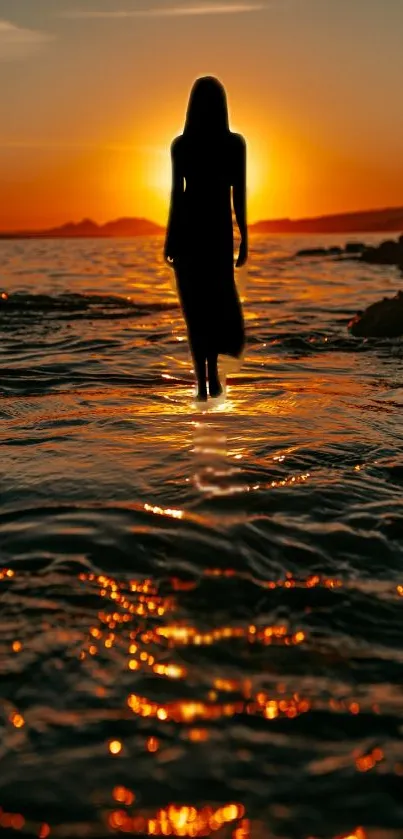 Silhouette walking in ocean at sunset with golden reflections.