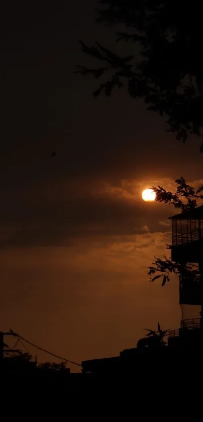 A dark silhouette of buildings against a sunset sky.