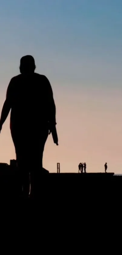 Silhouette of couple walking at sunset with vibrant sky.