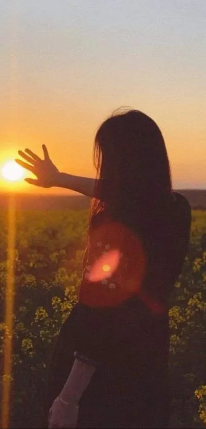 A silhouette reaching towards sunset over a blossoming field.