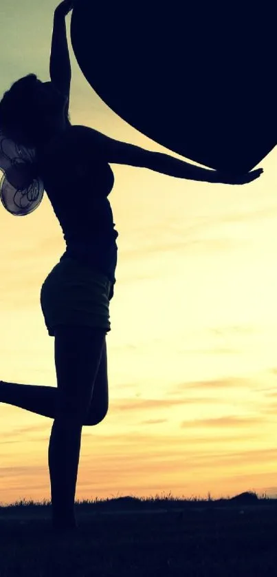 Silhouette of woman holding heart at sunset.