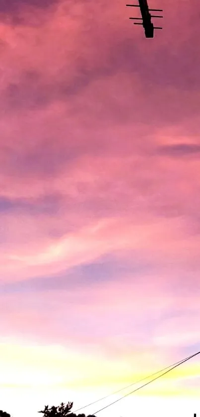 Pink and purple sunset sky with silhouette elements.