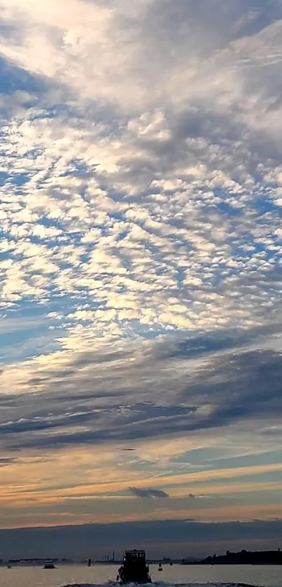 A serene sunset sky over the ocean with vibrant clouds.