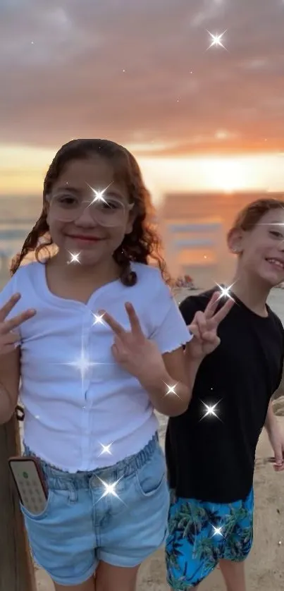 Two kids at a beach with sparkles during sunset.