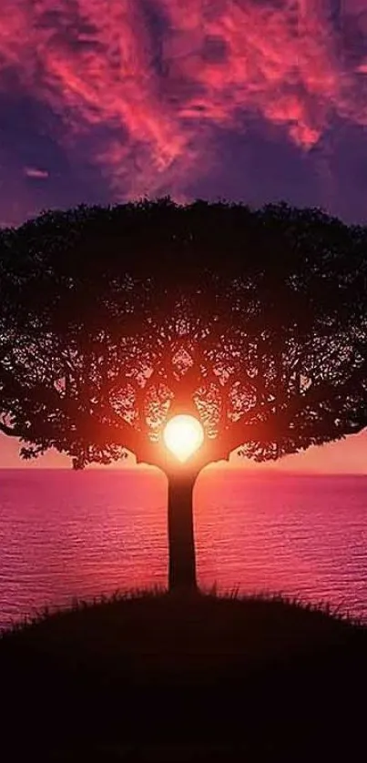 Mobile wallpaper of a tree silhouette against a vibrant sunset over the ocean.