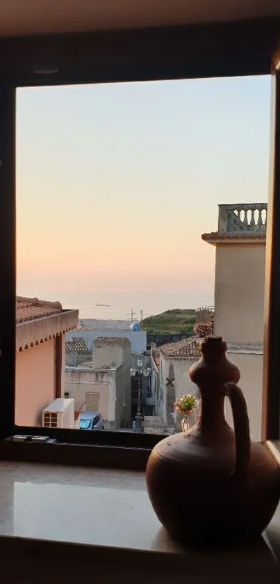 Sunset view through a rustic window overlooking a coastal town.