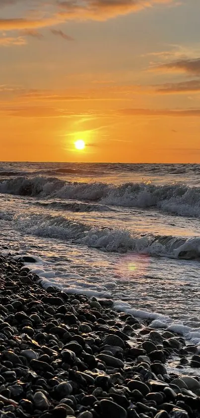 Beautiful sunset with waves and pebbles on a beach, perfect for wallpaper.