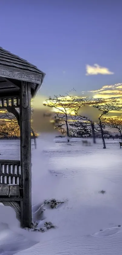 Winter gazebo with snowy landscape at sunset.