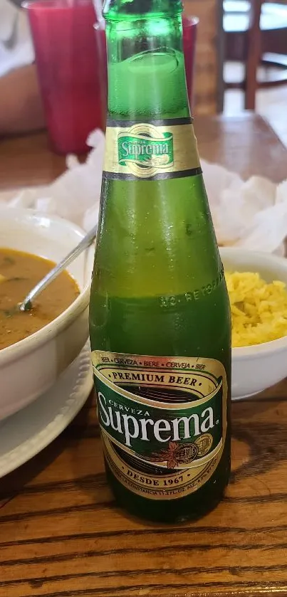 Suprema beer bottle on a dining table with food.