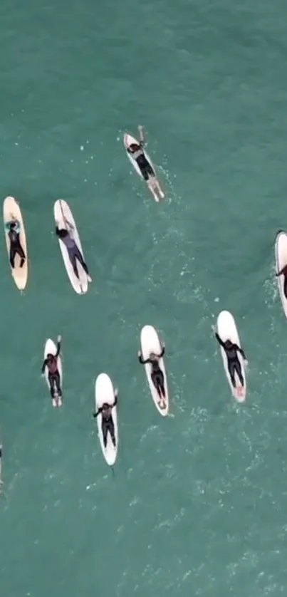 Aerial view of surfers on turquoise ocean waves.