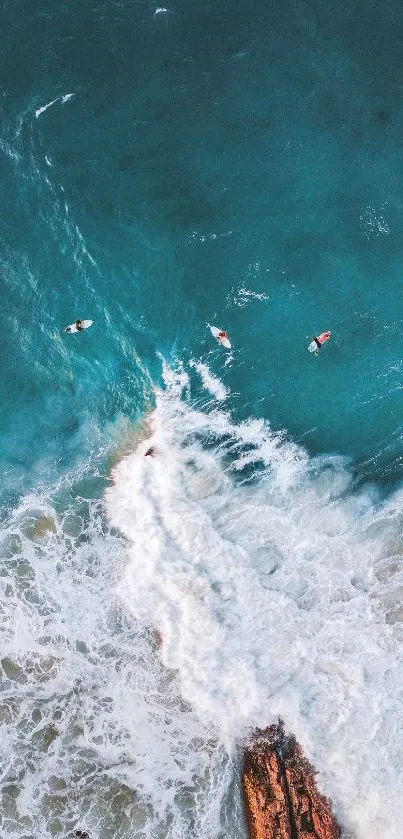 Aerial view of surfers on turquoise ocean waves with rocky coast.