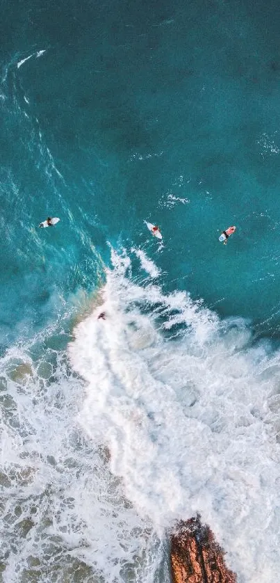 Aerial view of surfers riding ocean waves with turquoise water.