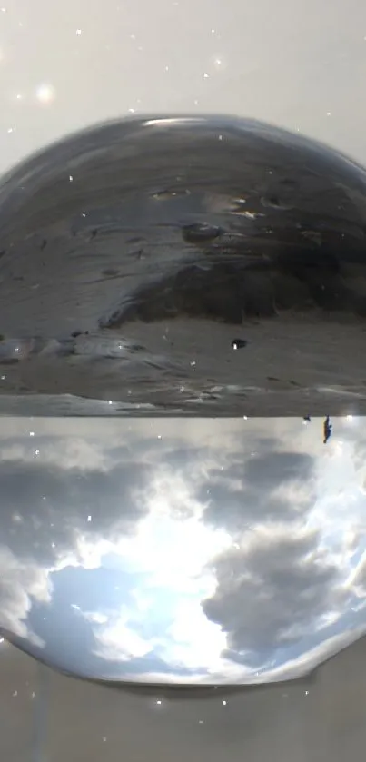 Reflective glass orb with surreal sky and gray tones.