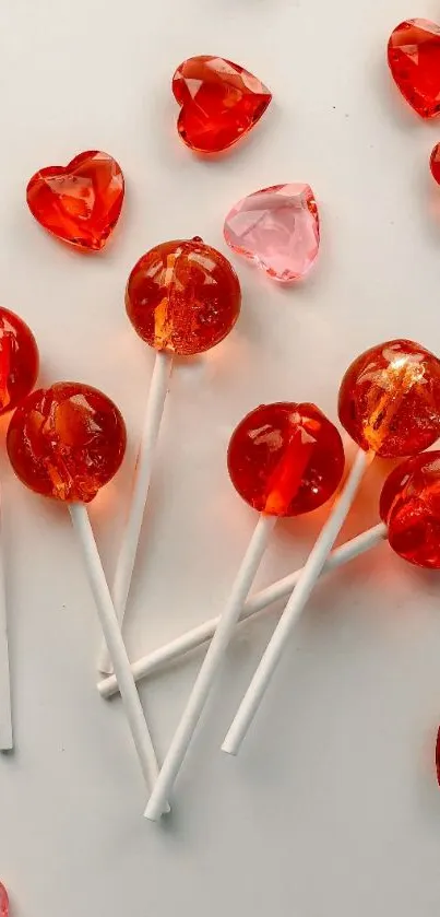 Red heart lollipops and pink candies on a white background.