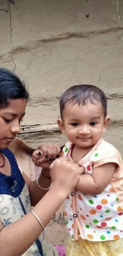 Sibling bonding with baby smiling in rustic setting.