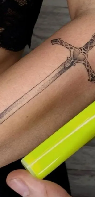 Intricate sword tattoo on an arm, perfect for mobile wallpaper.