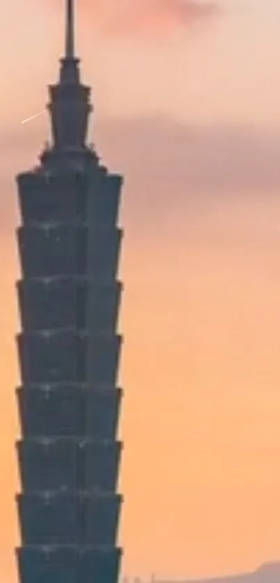 Taipei 101 tower silhouetted against an orange sunset sky.