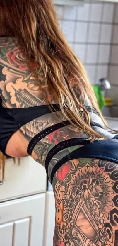 Woman with artistic tattoos in kitchen setting.