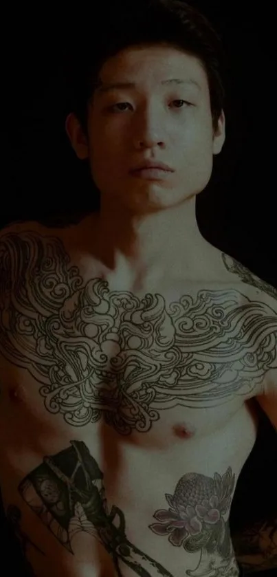 Tattooed male torso with intricate designs on a dark background.