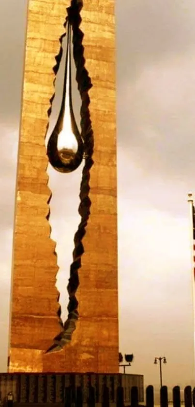 Tear of Grief Monument with bronze tones on a cloudy day.