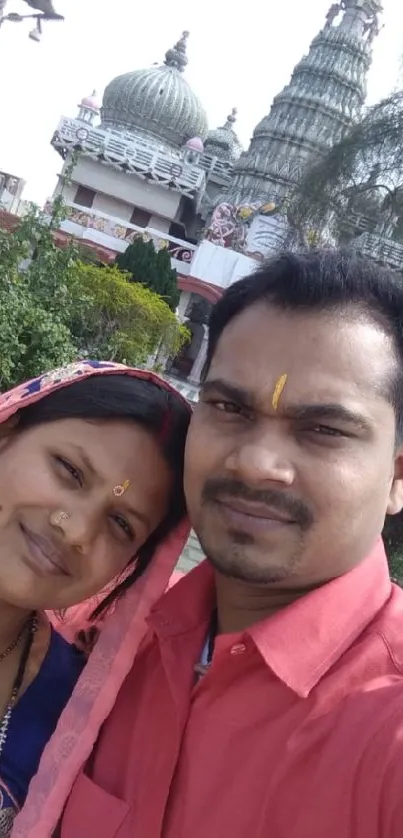 Couple in traditional attire with temple background.