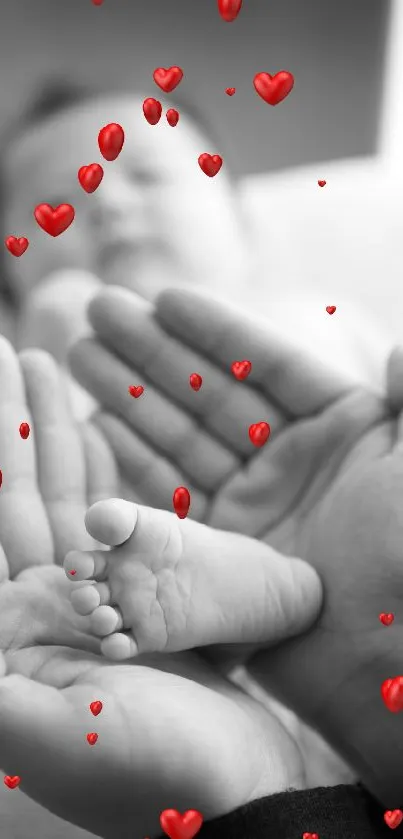 Black and white wallpaper of adult hands holding a baby's foot.