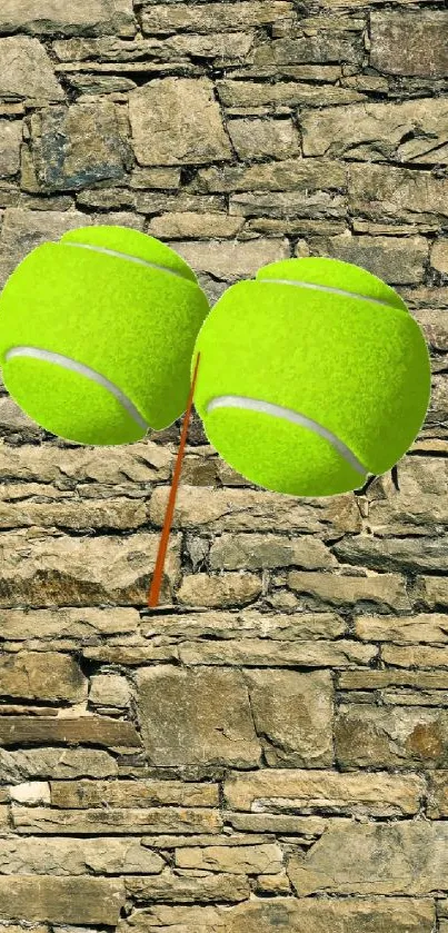 Two tennis balls against a stone brick wall.