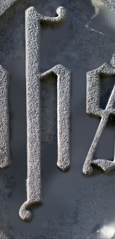 Textured stone monogram on a grey background.