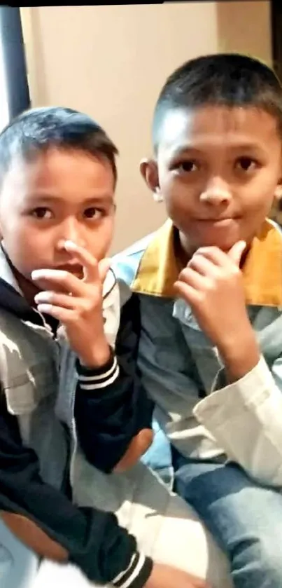 Two thoughtful boys seated together in a warm-toned casual setting.