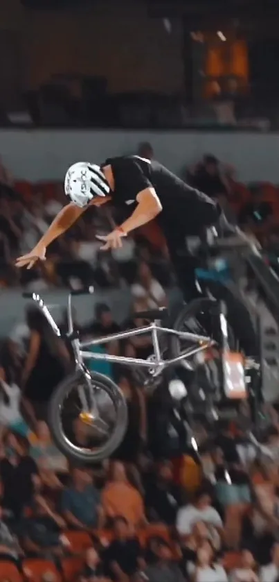 BMX rider performing a high jump stunt in a crowded arena.